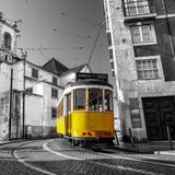 Fotobehang - Tram in een historische wijk in Lissabon, Gele tram tegen zwart witte achtergrond, 11 maten, incl behanglijm