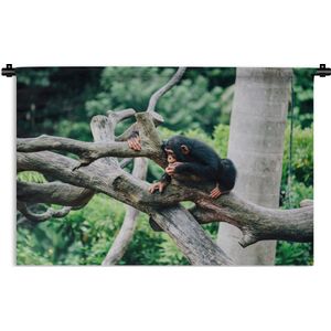Wandkleed Junglebewoners - Jonge chimpansee in de jungle Wandkleed katoen 90x60 cm - Wandtapijt met foto