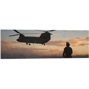 WallClassics - Vlag - Soldaat bij Legervliegtuig met Zonsondergang - 90x30 cm Foto op Polyester Vlag
