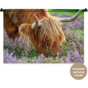 Wandkleed Schotse Hooglanders  - Grazende Schotse hooglander tussen paarse bloemen Wandkleed katoen 90x60 cm - Wandtapijt met foto