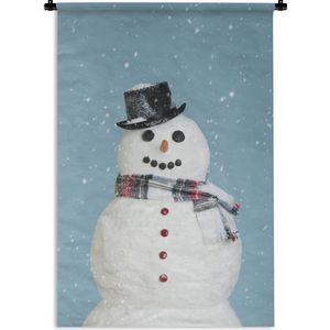 Wandkleed Kerst - Een blije sneeuwpop tijdens kerst met een lichtblauwe achtergrond Wandkleed katoen 60x90 cm - Wandtapijt met foto