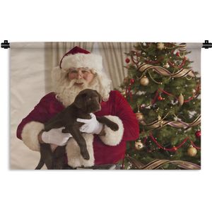 Wandkleed Kerst - De kerstman met een bruine hond in zijn handen Wandkleed katoen 150x100 cm - Wandtapijt met foto