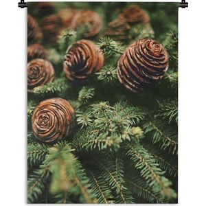 Wandkleed Kerst - Een close-up van dennenappels bij de kerstboom Wandkleed katoen 90x120 cm - Wandtapijt met foto