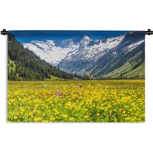 Wandkleed Bloemenweide - Gele bloemenweide voor besneeuwde bergen Wandkleed katoen 150x100 cm - Wandtapijt met foto
