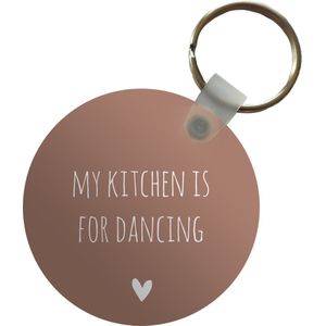 Sleutelhanger - Engelse quote My kitchen is for dancing met een hartje tegen een bruine achtergrond - Plastic - Rond - Uitdeelcadeautjes