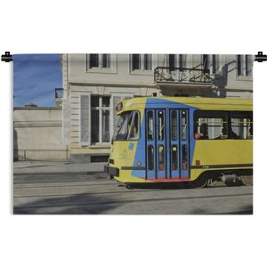 Wandkleed Tram - Een gele met blauwe tram rijdt door de straten van Brussel Wandkleed katoen 150x100 cm - Wandtapijt met foto