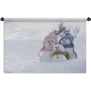 Wandkleed Kerst - Een familie van kerstpoppen op het besneeuwde landschap Wandkleed katoen 150x100 cm - Wandtapijt met foto