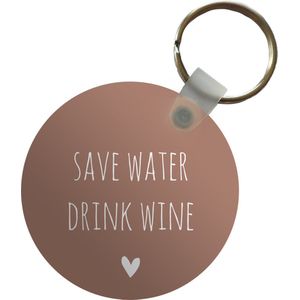 Sleutelhanger - Engelse quote Save water drink wine met een hartje tegen een bruine achtergrond - Plastic - Rond - Uitdeelcadeautjes