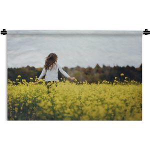Wandkleed Kinderen in de natuur - Meisje rent door een veld met gele bloemen Wandkleed katoen 60x40 cm - Wandtapijt met foto