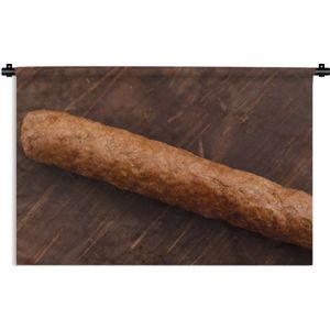 Wandkleed Frikandel - Een heerlijke frikandel op een houten achtergrond Wandkleed katoen 150x100 cm - Wandtapijt met foto