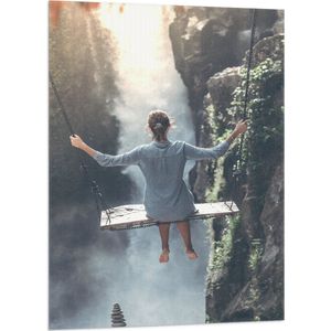 WallClassics - Vlag - Vrouw op Schommel boven Landschap - 70x105 cm Foto op Polyester Vlag