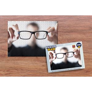 Puzzel Een close-up man met bril die de bril toont aan de camera. - Legpuzzel - Puzzel 500 stukjes