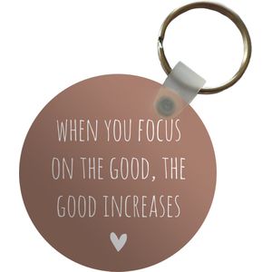 Sleutelhanger - Engelse quote When you focus on the good, the good increases tegen een bruine achtergrond - Plastic - Rond - Uitdeelcadeautjes
