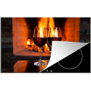 KitchenYeah® Inductie beschermer 80x52 cm - Twee glazen rode wijn bij een open haard - Kookplaataccessoires - Afdekplaat voor kookplaat - Inductiebeschermer - Inductiemat - Inductieplaat mat