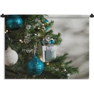 Wandkleed Kerst - Een close-up van een kerstboom met blauw en witte kerstballen Wandkleed katoen 60x45 cm - Wandtapijt met foto