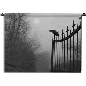 Wandkleed Kraaiachtigen - Een kraai zit bovenop een zwart ijzeren hek in het zwart-wit Wandkleed katoen 120x90 cm - Wandtapijt met foto