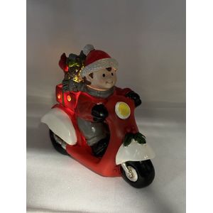 Kerstbeeldje jongen op rode scooter met LED - rood + grijs + groen cadeau - polyresin - 12 cm hoog x 16 cm x 8 cm – Kerstdecoratie
