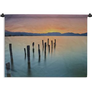 Wandkleed Kalm - Palen in het kalme water bij zonsondergang Wandkleed katoen 180x135 cm - Wandtapijt met foto