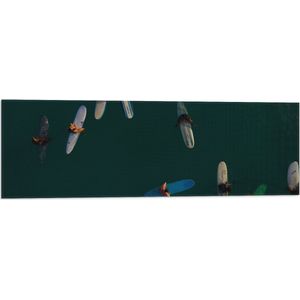 WallClassics - Vlag - Bovenaanzicht van Groep Surfers op Oceaan - 90x30 cm Foto op Polyester Vlag