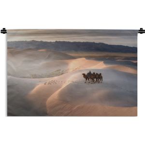 Wandkleed Gobi Woestijn - Man op kameel met twee andere kamelen in de Gobi woestijn in Mongolië Wandkleed katoen 90x60 cm - Wandtapijt met foto