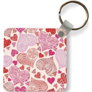 Sleutelhanger - Een illustratie met roze en rode hartjes - Plastic - Rond - Uitdeelcadeautjes