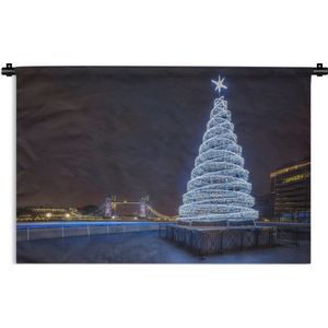 Wandkleed Kerst - Een verlichtte kerstboom bij de Tower Bridge in Engeland Wandkleed katoen 180x120 cm - Wandtapijt met foto XXL / Groot formaat!