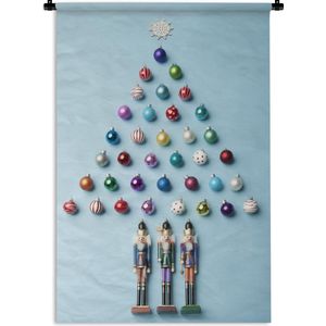 Wandkleed Kerst - Een kerstboom gemaakt van kerstballen op een lichtblauwe achtergrond Wandkleed katoen 90x135 cm - Wandtapijt met foto