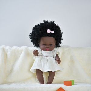 Kleine reborn baby pop 'Yara' - 35 cm - Wit jurkje - Soft vinyl - Donkere pop met zwarte krullen