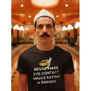 Shirt - Never make eye contact while eating a banana - Wurban Wear | Grappig shirt | Leuk cadeau | Unisex tshirt | Meme shirt | Vaderdag | Dirty shirt | Zwart