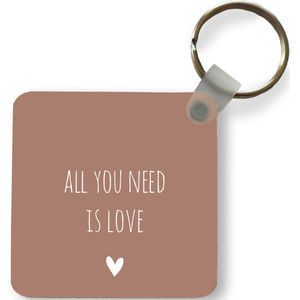 Sleutelhanger - Uitdeelcadeautjes - Engelse quote All you need is love met een hartje tegen een bruine achtergrond - Plastic