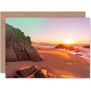 Blanco verjaardagskaart met zonsondergang op het strand, rotsen, zand