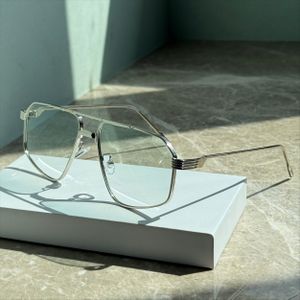 Een paar stijlvolle metalen zilveren brillen met lichtgroene lenzen.