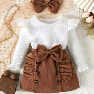 Een drietal met een kleur lange mouw top met strikdecoratie en een matchende rok, inclusief een haarband, voor buiten