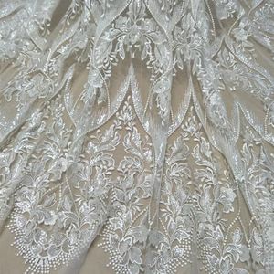 Een bruidsjurk, Bruidsjurk met pailletten en kant, bruidstulestof in ivoor