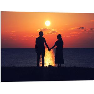 PVC Schuimplaat - Silhouet van Koppel Hand in Hand bij de Zee tijdens Zonsondergang - 80x60 cm Foto op PVC Schuimplaat (Met Ophangsysteem)