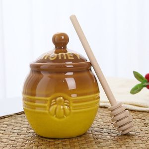 Glazen honingpot met een houten lepel