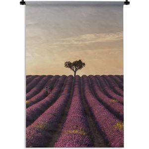 Wandkleed Bloemenweide - Lavendelveld met een eenzame boom bij zonsondergang Wandkleed katoen 60x90 cm - Wandtapijt met foto