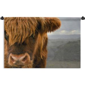 Wandkleed Schotse hooglander - Close up van een Schotse hooglander met de bergen op de achtergrond Wandkleed katoen 150x100 cm - Wandtapijt met foto