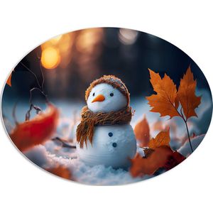 PVC Schuimplaat Ovaal - Sneeuwpop met Bruine Sjaal en Muts in de Sneeuw tussen de Herfstbladeren - 108x81 cm Foto op Ovaal (Met Ophangsysteem)