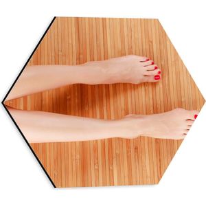 Dibond Hexagon - Bovenaanzicht van Vrouwen Benen met Roodkleurige Teennagels op Houten Ondergrond - 30x26.1 cm Foto op Hexagon (Met Ophangsysteem)
