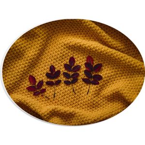 PVC Schuimplaat Ovaal - Kleine Rode Blaadjes van Plant op Okergeel Deken - 28x21 cm Foto op Ovaal (Met Ophangsysteem)