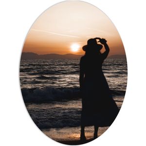 PVC Schuimplaat Ovaal - Vrouw kijkend naar de Zee en Zonsondergang - 60x80 cm Foto op Ovaal (Met Ophangsysteem)