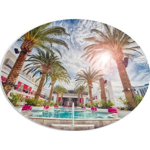 PVC Schuimplaat Ovaal - Zwembad - Bomen - Palmbomen - Bedjes - Roze - Hotel - Gebouw - Zon - Tropisch - 80x60 cm Foto op Ovaal (Met Ophangsysteem)