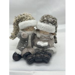 Kerstbeeldjes - Set van 2 stuks aan elkaar- Kerst jongen & meisje -taupe + gebreide mutsen - Kerstdecoratie - 10.5x8.5x9.5cm