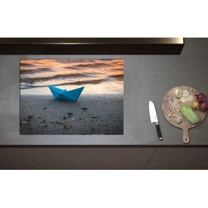 Inductieplaat Beschermer - Blauwe Papieren Origami Bootje Aangespoeld op het Strand tijdens Opkomende Zon - 75x55 cm - 2 mm Dik - Inductie Beschermer - Bescherming Inductiekookplaat - Kookplaat Beschermer van Zwart Vinyl
