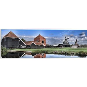 PVC Schuimplaat- Boerderij met Windmolens aan het Water - 60x20 cm Foto op PVC Schuimplaat