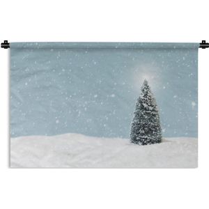 Wandkleed Kerst - Een kerstboom in een besneeuwd landschap en een blauwe hemel Wandkleed katoen 150x100 cm - Wandtapijt met foto