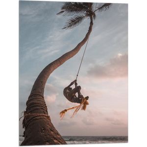 WallClassics - Vlag - Man Slingerend aan Kromme Palmboom - 60x80 cm Foto op Polyester Vlag