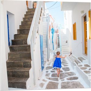 PVC Schuimplaat - Meisje in Blauwe Jurk door de Straten van Santorini, Griekenland - 80x80 cm Foto op PVC Schuimplaat (Met Ophangsysteem)