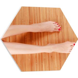 PVC Schuimplaat Hexagon - Bovenaanzicht van Vrouwen Benen met Roodkleurige Teennagels op Houten Ondergrond - 50x43.5 cm Foto op Hexagon (Met Ophangsysteem)